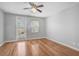 This bedroom features hardwood floors, a ceiling fan, a window and a glass door at 1605 Napoli W Dr, Sarasota, FL 34232