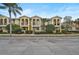 Well-maintained yellow townhome featuring a private balcony and neatly manicured landscaping in front at 1605 Napoli W Dr, Sarasota, FL 34232