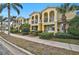 Charming townhomes featuring private balconies, lush landscaping, and bright yellow facades at 1605 Napoli W Dr, Sarasota, FL 34232