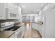 Well-lit kitchen features white cabinets, modern appliances, tile floors, and a seamless transition into the living area at 1605 Napoli W Dr, Sarasota, FL 34232