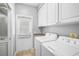Functional laundry room with cabinetry, countertop, and modern washer and dryer at 1605 Napoli W Dr, Sarasota, FL 34232