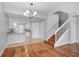 Open concept living room with hardwood floors, staircase with white railings, and a view into the adjacent kitchen area at 1605 Napoli W Dr, Sarasota, FL 34232