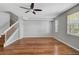 A modern living room featuring hardwood floors, a ceiling fan, neutral wall color, and natural light from the windows at 1605 Napoli W Dr, Sarasota, FL 34232