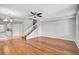 Spacious living area showcasing hardwood floors, a staircase, and a view into the kitchen with a modern chandelier at 1605 Napoli W Dr, Sarasota, FL 34232