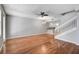 Bright living room featuring hardwood floors, a modern ceiling fan, an elegant chandelier, and a staircase with white railings at 1605 Napoli W Dr, Sarasota, FL 34232