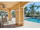 Inviting community pool area with covered seating, columns, and palm tree accents at 1605 Napoli W Dr, Sarasota, FL 34232