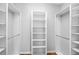 A large walk-in closet with shelving, hanging racks and wood floors at 1605 Napoli W Dr, Sarasota, FL 34232