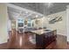 Open concept kitchen and living room area with beautiful hardwood floors, coffered ceilings, and a center island at 2500 Jamaica St, Sarasota, FL 34231