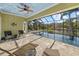Inviting enclosed pool area with comfortable lounge seating, ceiling fan, and clear view of the backyard at 2500 Jamaica St, Sarasota, FL 34231
