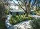 Inviting single-story home surrounded by lush greenery, featuring a well-maintained lawn and elegant landscaping at 4939 Myakka Valley Trl, Sarasota, FL 34241