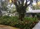 Landscaped front yard with lush greenery and colorful flowers, and a glimpse of the home's exterior at 4939 Myakka Valley Trl, Sarasota, FL 34241
