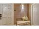 Cozy condo entryway with neutral tones, a bench with pillows and a stylish wall sconce at 505 S Orange Ave # 501, Sarasota, FL 34236