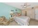 Comfortable bedroom with ceiling fan, patterned bedding, and a cozy armchair at 535 Spring Lakes Blvd, Bradenton, FL 34210