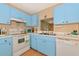 The kitchen features vintage-style blue cabinets and white appliances at 535 Spring Lakes Blvd, Bradenton, FL 34210