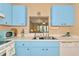 Well-lit kitchen featuring light blue cabinets and a pass-through to the dining area at 535 Spring Lakes Blvd, Bradenton, FL 34210