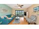 Comfortable living room with a blue sofa, coastal decor, and sliding glass doors to the lanai at 535 Spring Lakes Blvd, Bradenton, FL 34210
