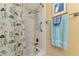 Shower with flamingo patterned curtain, grab bar, and hand-held shower head at 535 Spring Lakes Blvd, Bradenton, FL 34210