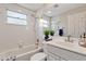 Bathroom with white tiled walls, shower-tub combo, and a large vanity mirror at 6706 Fairway Gardens Dr # 6706, Bradenton, FL 34203