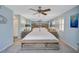 Calming main bedroom featuring a king-size bed, mirrored wall, and soft blue tones for a relaxing retreat at 1185 Coquille St # 305, Sarasota, FL 34242