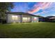 Dusk view of the backyard features a screened lanai and manicured lawn at 12029 Perennial Pl, Lakewood Ranch, FL 34211