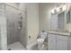 Full bathroom featuring a tiled walk-in shower, toilet and vanity with decorative lighting at 12029 Perennial Pl, Lakewood Ranch, FL 34211