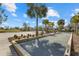 Bocce ball court in a community setting with palm trees, a sand volleyball court, and benches at 12029 Perennial Pl, Lakewood Ranch, FL 34211