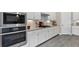The kitchen features white cabinets, stainless steel appliances, granite counters, and a tile backsplash at 12029 Perennial Pl, Lakewood Ranch, FL 34211