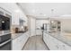 The kitchen features white cabinets, granite countertops, stainless steel appliances, and an island with seating at 12029 Perennial Pl, Lakewood Ranch, FL 34211