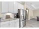 Bright kitchen showcases stainless steel refrigerator, white cabinets, and granite countertops at 12029 Perennial Pl, Lakewood Ranch, FL 34211