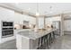 The kitchen features white cabinets, stainless steel appliances, granite counters, and an island with seating at 12029 Perennial Pl, Lakewood Ranch, FL 34211