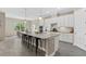 Modern kitchen features an island with seating, white cabinets, granite countertops, and stainless steel appliances at 12029 Perennial Pl, Lakewood Ranch, FL 34211