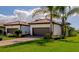 This exterior view captures the home's clean curb appeal, tile roof, brown garage doors, and lush green lawn at 12251 Myrtle Bay Ct, Sarasota, FL 34238