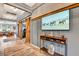 Inviting entryway showcasing wood-look flooring, rustic barn doors and a media display at 3218 Big Sky Way, Bradenton, FL 34211