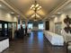 Large elegant ballroom boasts chandeliers, wood floors, and neutral walls for customizable event space at 4202 Caddie E Dr # 202, Bradenton, FL 34203