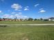 Scenic view of a lush green golf course under a bright blue sky, with residential homes in the background at 4202 Caddie E Dr # 202, Bradenton, FL 34203