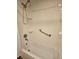Bright white bathroom with subway tile surround, hand-held shower and grab bar at 4900 38Th S Way # 201, St Petersburg, FL 33711