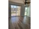 Living area boasts wood-look flooring and sliding glass doors to an outdoor balcony at 4900 38Th S Way # 201, St Petersburg, FL 33711