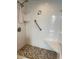 Walk-in shower features a pebble floor, white subway tile and safety grab bar at 4900 38Th S Way # 201, St Petersburg, FL 33711