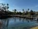 Scenic view of a tranquil pond with a wooden bridge and fountain amidst lush greenery at 5036 Barrington Cir # 2401, Sarasota, FL 34234