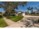 Charming single-story home featuring an attached garage, well-maintained lawn, and mature trees on a sunny day at 5500 Bayou Grande Ne Blvd, St Petersburg, FL 33703