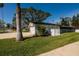 Exterior view of home with a tidy side yard, featuring mature palm trees and well-maintained greenery at 5500 Bayou Grande Ne Blvd, St Petersburg, FL 33703