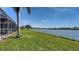Enjoy a view of the lake from this grassy backyard with a screened-in pool and patio at 6920 74Th Street E Cir, Bradenton, FL 34203