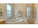 Bright bathroom features a garden tub with tile surround and glass shower enclosure at 6920 74Th Street E Cir, Bradenton, FL 34203