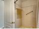 This bathroom features a tiled shower with a hand rail and open access from the white paneled bathroom door at 6920 74Th Street E Cir, Bradenton, FL 34203