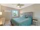 Tranquil bedroom featuring a comfortable queen bed, a ceiling fan and palm tree view at 6920 74Th Street E Cir, Bradenton, FL 34203