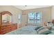 Comfortable bedroom features a serene lake view and a classic wood dresser at 6920 74Th Street E Cir, Bradenton, FL 34203