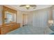 This bedroom features a ceiling fan, and a dresser with a mirror and a view of the closet door at 6920 74Th Street E Cir, Bradenton, FL 34203