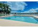 Enjoy the inviting community pool with ample seating, scenic lake views, and towering palm trees at 6920 74Th Street E Cir, Bradenton, FL 34203