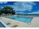 Community pool featuring lounge chairs, palm trees, and a view of the lake at 6920 74Th Street E Cir, Bradenton, FL 34203