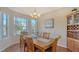 Elegant dining room filled with natural light, featuring wood floors and an adjacent built-in bar at 6920 74Th Street E Cir, Bradenton, FL 34203